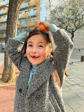 little girl with a orange on her head