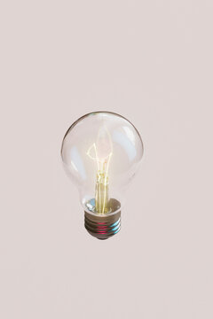  Illuminated Light Bulb on Soft Pink Background