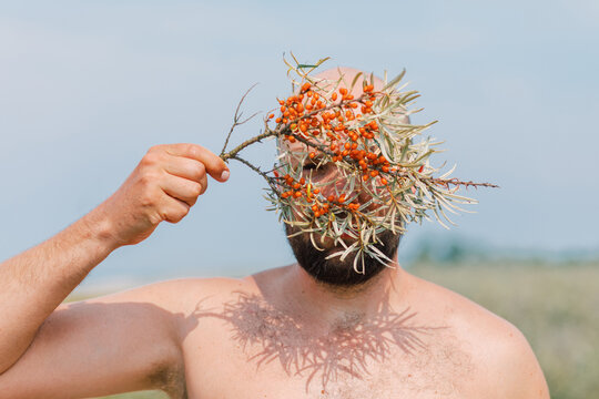 Man with Sea Buckthorn Branch on Face