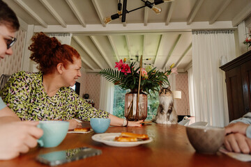 family tea time with mother, kids and cat