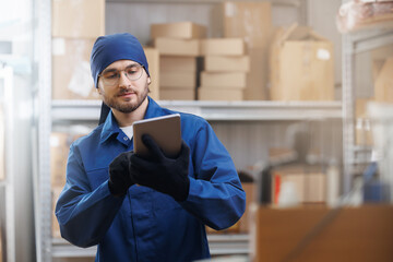 Online service of logistic import export concept. Young worker in blue uniform use computer tablet...