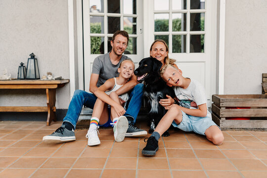 Outdoor family portrait of 4 and a black dog