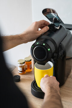 Man using capsule coffee maker at home