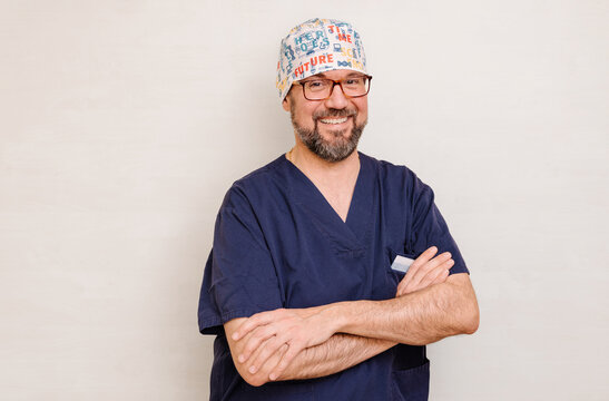 Friendly male nurse in scrubs with folded arms