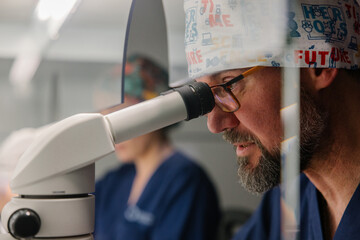 Researcher engages in scientific observation through a microscope