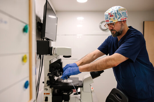 Healthcare professional operating a microscope