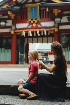 Mother braiding her sons hair 