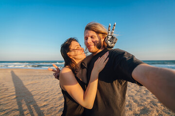 Wide angle selfie of a loving couple at the beach during the sunny day