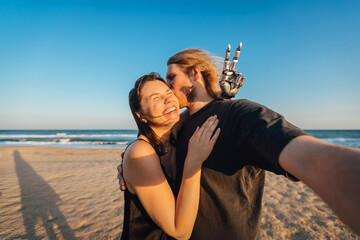 Wide angle selfie of couple in love at the beach during the sunset