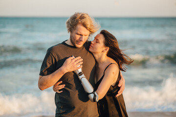 Couple in love hugging at the ocean beach during the sunset