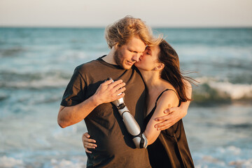 Couple in love hugging and kissing at the ocean beach during sunset