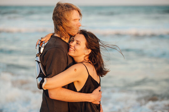 Happy couple hugging at the ocean beach during the sunset - Powered by Adobe