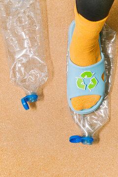 Female foot crushes a plastic bottle before sending it for recycling