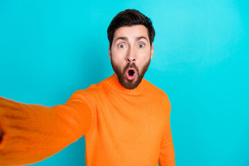 Photo of shocked nice young man wear orange trendy clothes make selfie isolated on cyan color...
