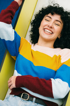 Pure joy emanates from a woman in a colorful striped sweater.