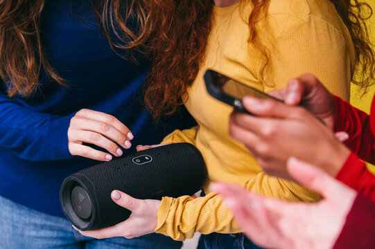 Friends enjoying music from a portable speaker