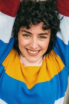 Cheerful woman smiling in colorful striped sweater