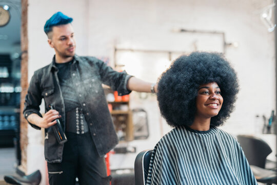 hairdresser combing his client's afro hair