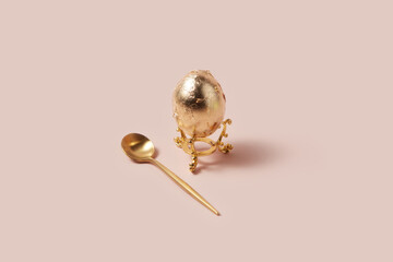 Imperial spoon lying next to gold painted egg for festive atmosphere