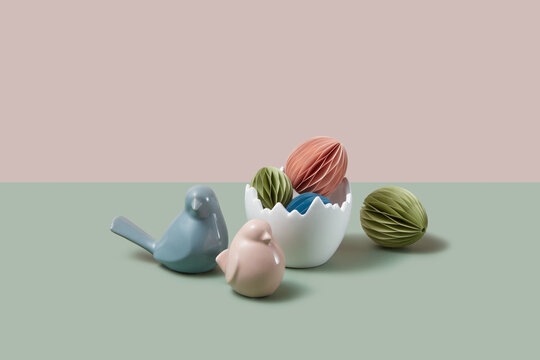 Vase with multicoloured paper crafts next to ceramic birds 