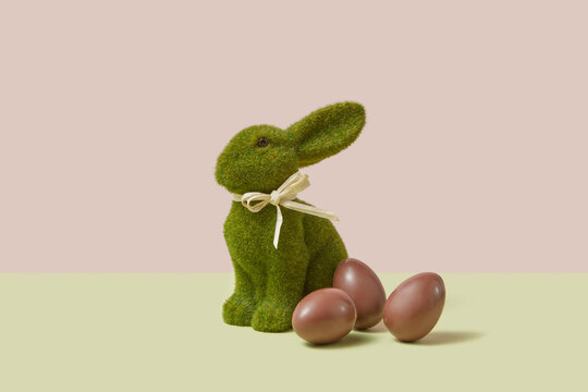 Easter bunny made of green grass chocolate eggs in studio