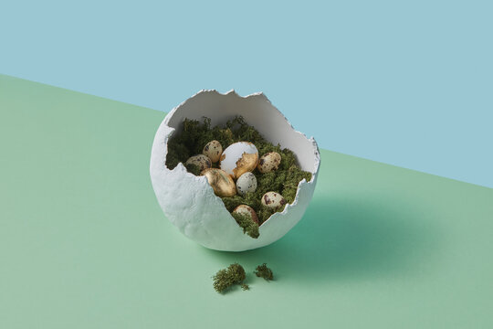 Fractured sphere vase filled with festive eggs laying on grass