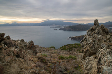 Aerial view of rocks and water with distant mountains in Costa Brava in Catalonia