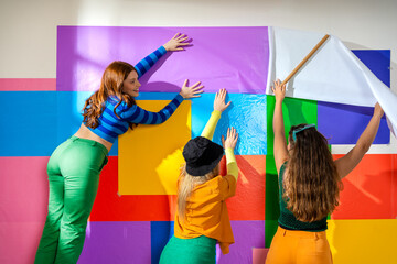 young women doing a handmade wall collage 