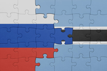 puzzle with the colourful national flag of botswana and flag of russia.