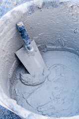 a cement mixer mixing into a cement bowl with a spatula