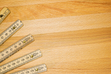 Yardstick like a fan on a wooden board