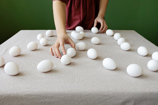 The girl is making a drawing out of eggs 