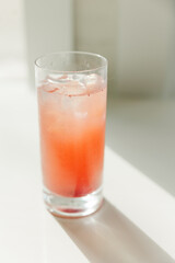High glass filled with orange juice and an ice cube