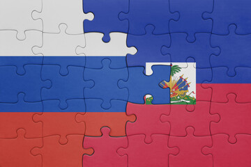 Fototapeta premium puzzle with the colourful national flag of haiti and flag of russia.