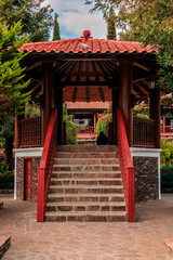 the red wooden structure in the park is very colorful with red and white accents