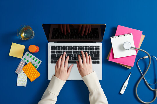 Doctor using laptop and key the prescription order.