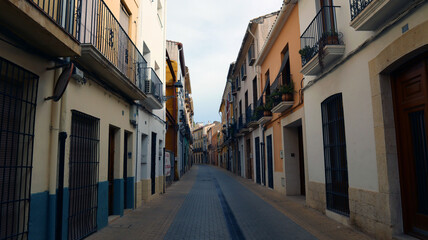 Obraz premium Street in the old Spanish city of Denia, with colorful ancient houses, stone pavement 