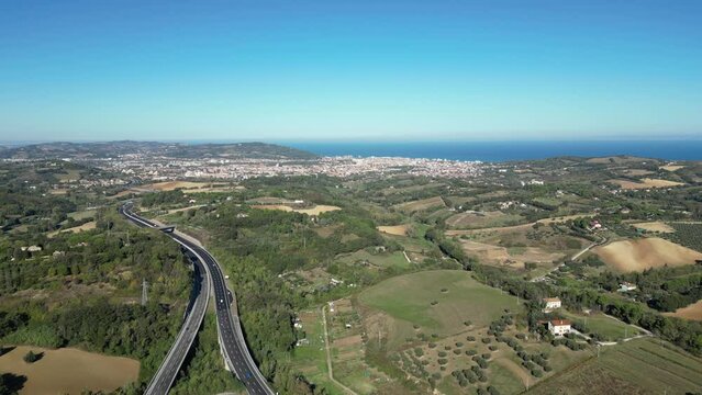 Aerial view showcasing A14 motorway in Pesaro hills and the Adriatic Sea in the background