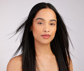 Woman, portrait and hair care with wind in studio for growth, keratin treatment or shampoo on white...