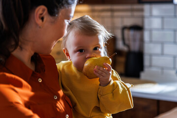 woman with cute daughter eating fruit