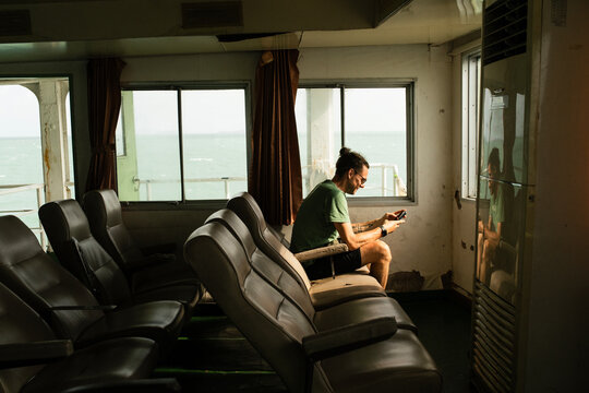 Young man sitting on an empty ferry boat