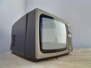 a small black television sits on top of a wooden table
