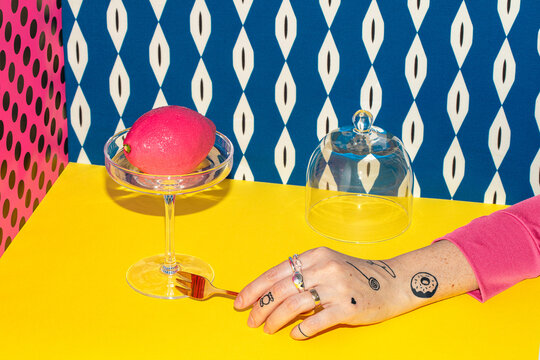 Still life with an unusual pink dessert in the shape of a lemon fruit