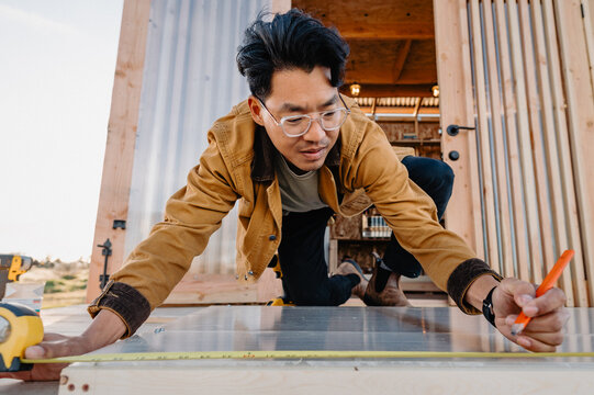 man measuring plexiglass