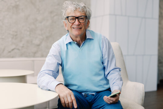 Happy male boomer Seated with Smartphone