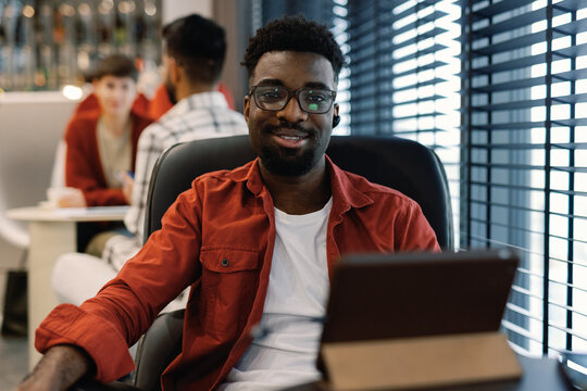 Smiling Man with Laptop in Casual Office