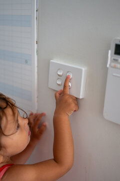 A child playing with the light button around the house