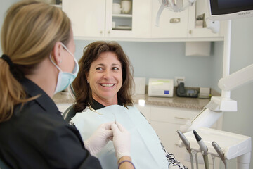 Fototapeta premium A woman is sitting in a dentist's chair smiling