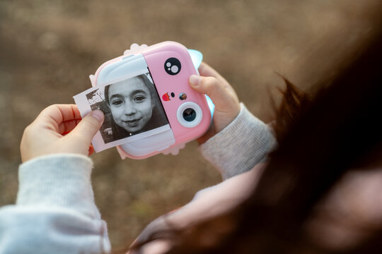 Child Reviews Selfie From Instant Print Camera.