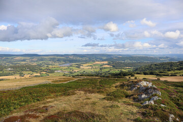 Scenic landscape with rolling hills, green grass, and fluffy clouds in the sky. Wales